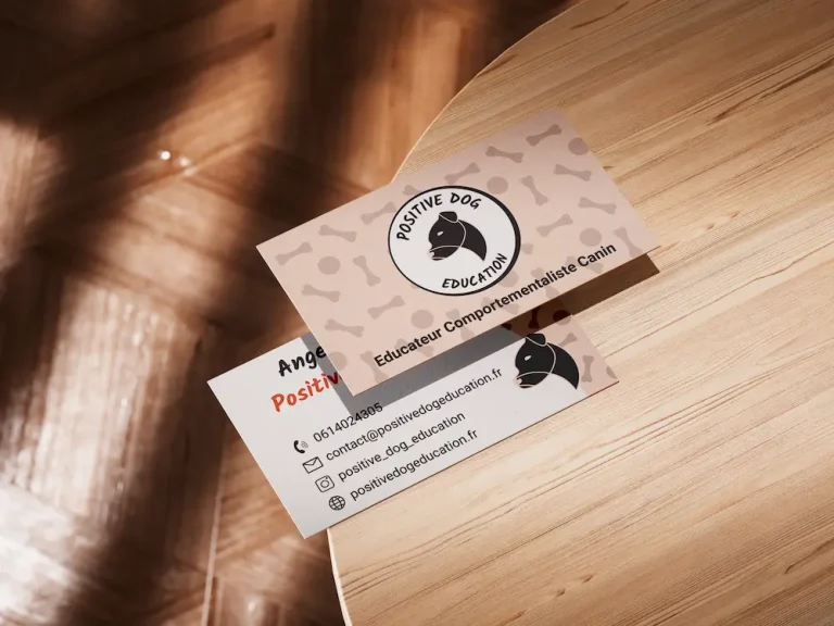 Carte de Visite recto et verso de positive Dog education, legerement supperposées, disposées sur une table.