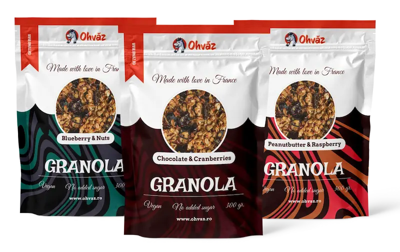 Trois paquets de c&eacute;r&eacute;ales avec des couleurs bleu-vert pour celui aux myrtille-noix, marron-rouge pour celui au chocolat-cranberries et rose-orange pour celui au beurre de cacahu&egrave;te.