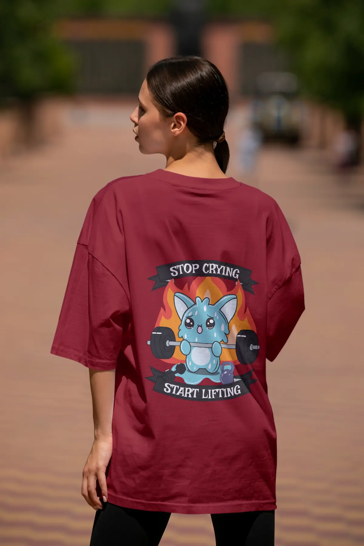 Femme de dos portant un Tshirt Crossfit laforge, avec une illustration d'un bonhomme mignon qui fait du crossfit avec le slogan " Stop Crying Start Lifting "